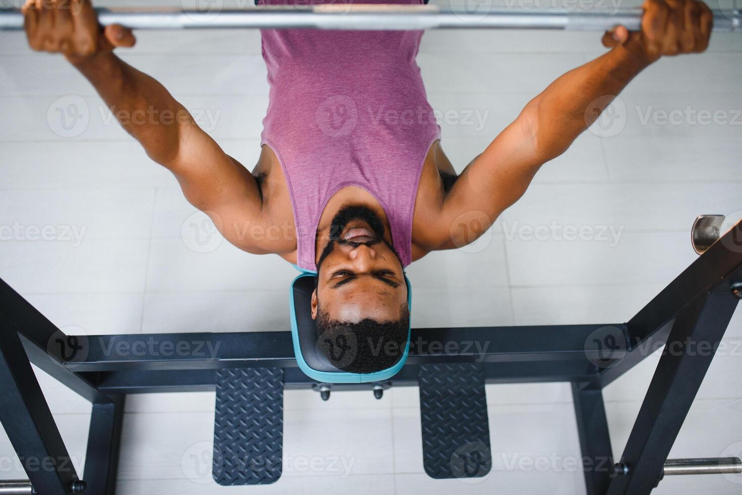 Weight lifter at the bench press lifting a barbell on an bench. photo