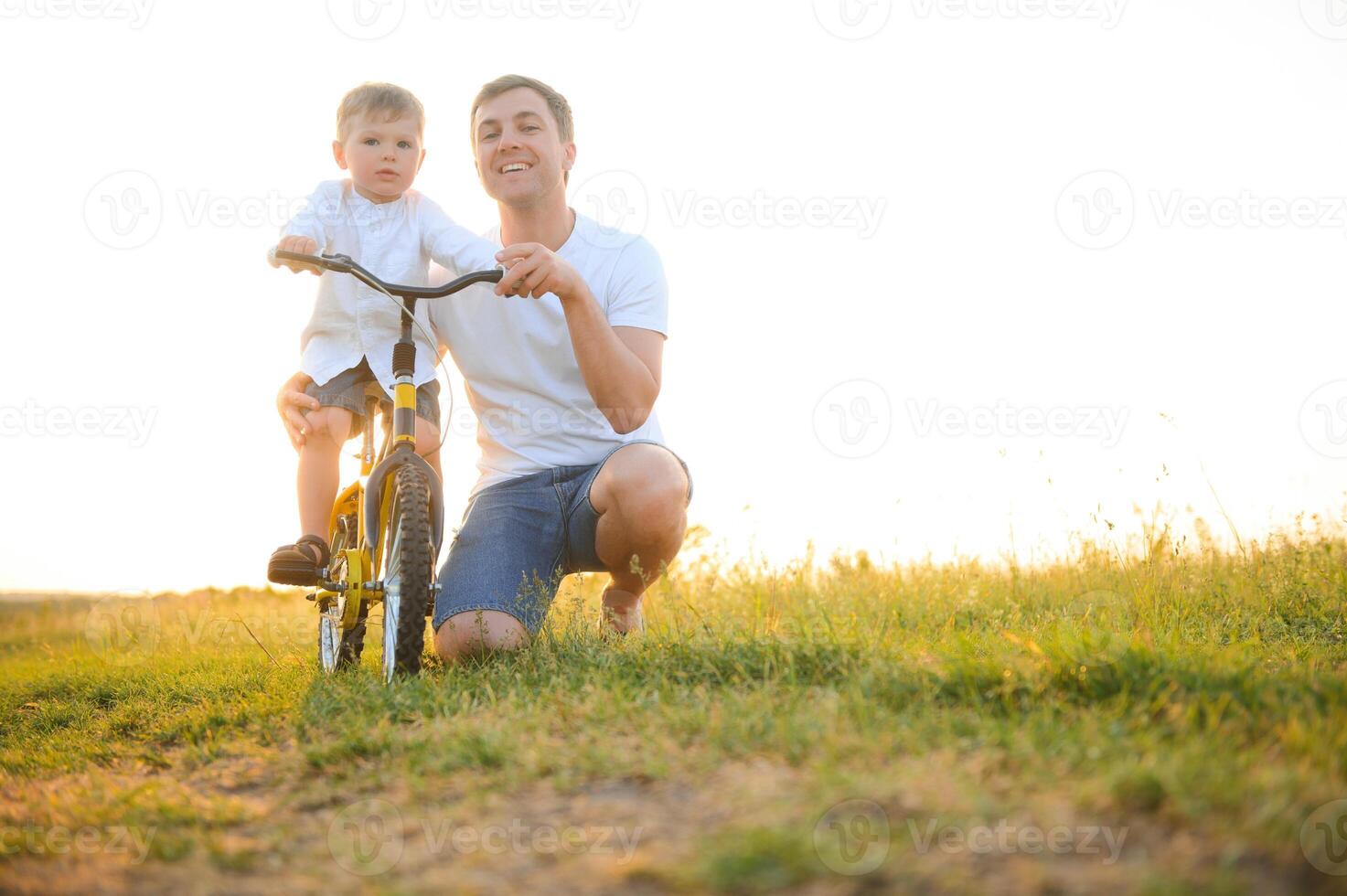 Father help his son ride a bicycle photo
