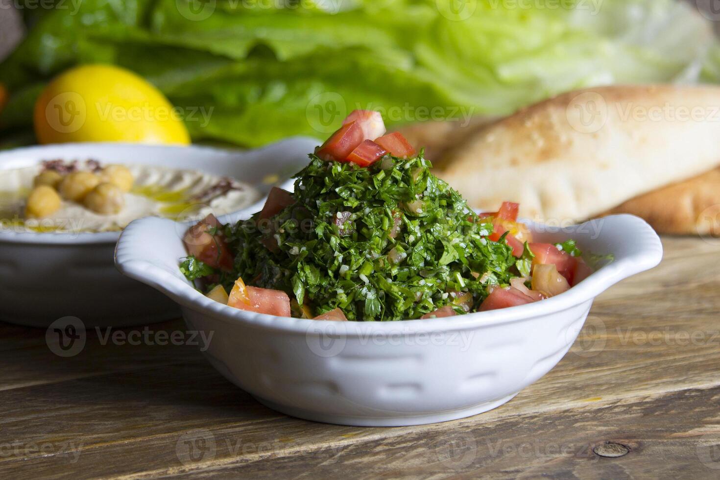 Tabouleh served in a dish side view on wooden table background photo