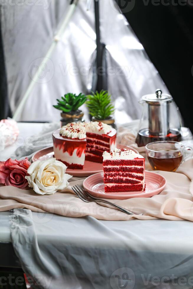 Premium Red Velvet cake and slice include cream, sugar with fork, cup of coffee and pot served on board isolated on napkin side view of cafe food photo
