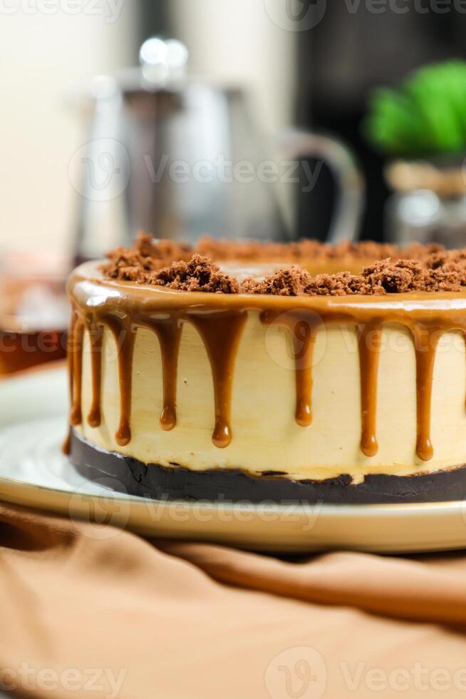 Salted Caramel Blondie cake include chocolate cream, sugar with fork, cup of coffee and pot served on board isolated on napkin side view of cafe food photo
