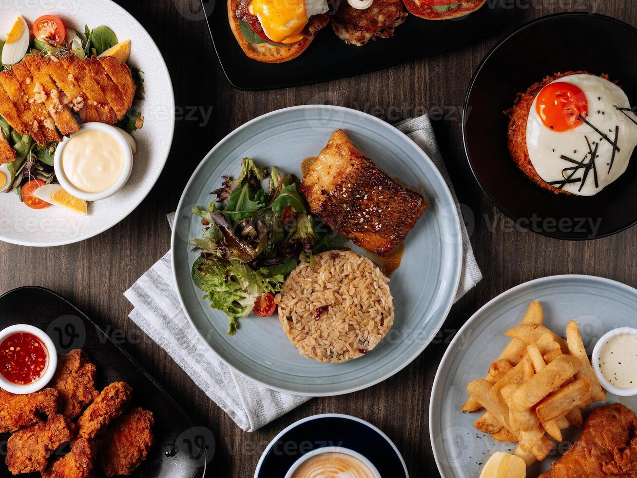 A breakfast fast food table Pan Fried Wild Cod Fish, Kimchi Fried Rice, Wing Zing, Fish And Chips, Caramel Latte, Eggs Blackstone, top view food photo