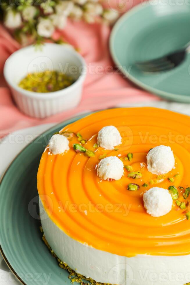 Mango Yogurt Cake topping with pistachio fork and flowers served in plate isolated on napkin side view cafe bake food photo
