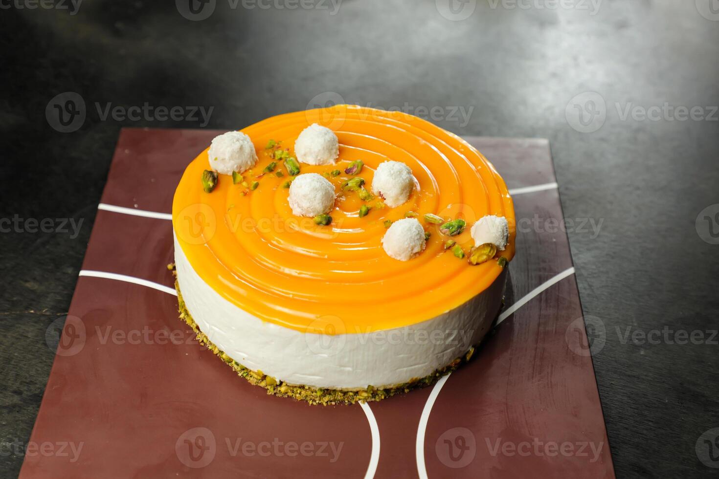 Mango Yogurt Cake topping with pistachio fork and flowers served in plate isolated on napkin side view cafe bake food photo