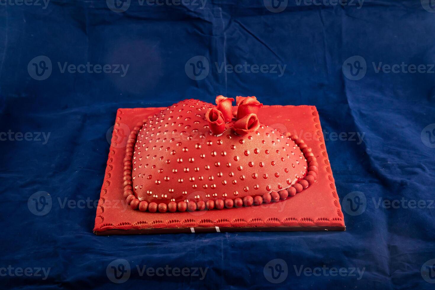 Heart Shaped red Cake with rose flowers, knife and fork served on board isolated on napkin side view of cafe baked food photo