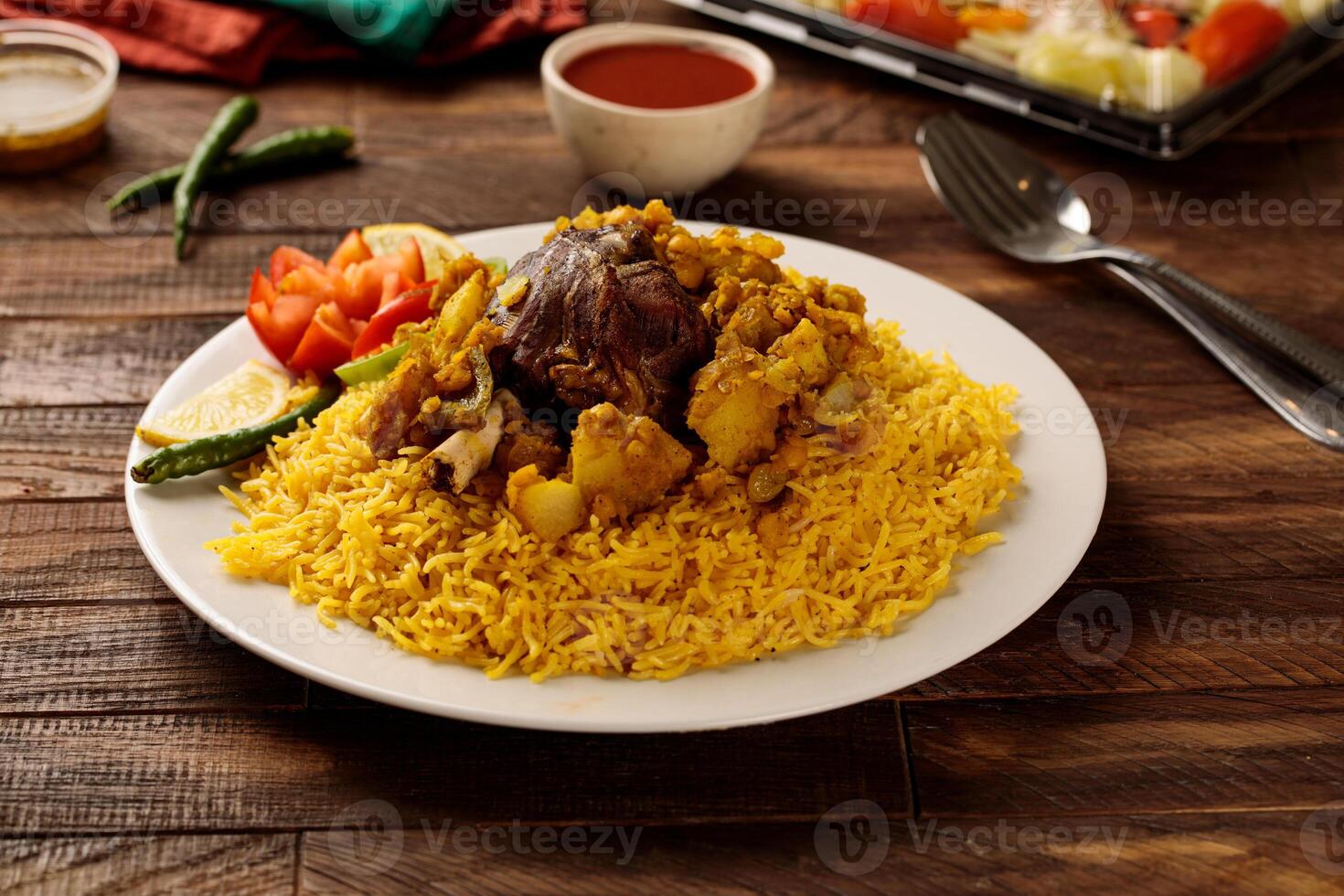 Beef behari biryani with salad and tomato sauce served in a dish isolated on wooden table background side view of fastfood photo