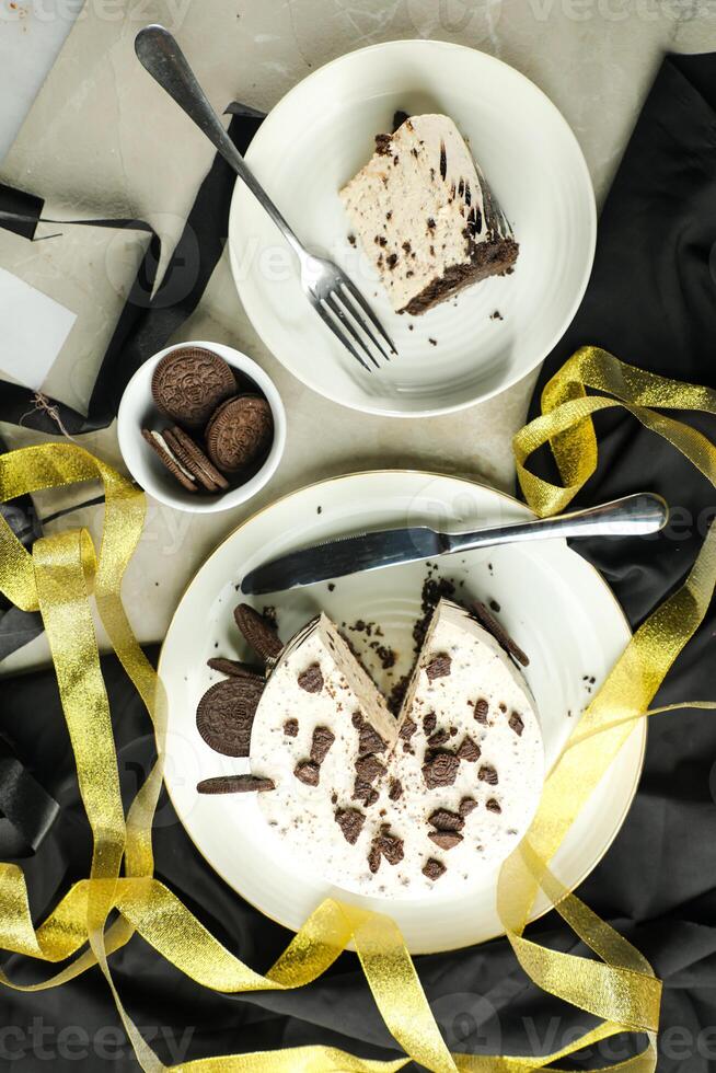 Oreo Cheesecake slice include chocolate, cream, sugar with fork and flowers served in plate isolated on napkin top view of cafe food photo