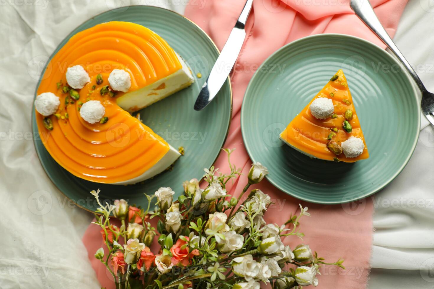Mango Yogurt Cake slice topping with pistachio fork and flowers served in plate isolated on napkin top view cafe bake food photo