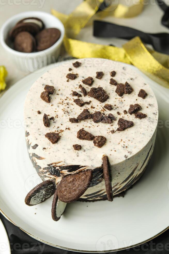 Oreo Cheesecake include chocolate, cream, sugar with fork and flowers served in plate isolated on napkin side view of cafe food photo