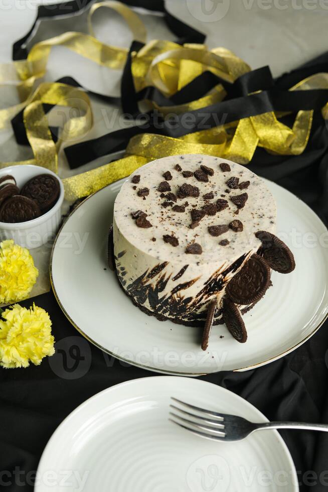 Oreo Cheesecake include chocolate, cream, sugar with fork and flowers served in plate isolated on napkin side view of cafe food photo