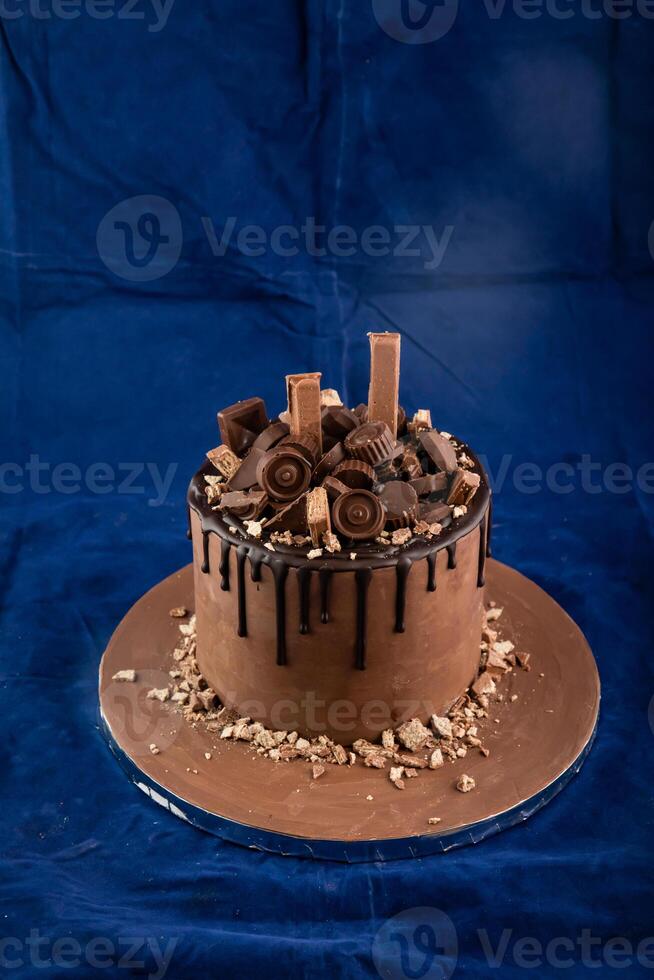 Chocolate Overloaded Cake with rose flowers, knife and fork served on board isolated on napkin side view of cafe baked food photo