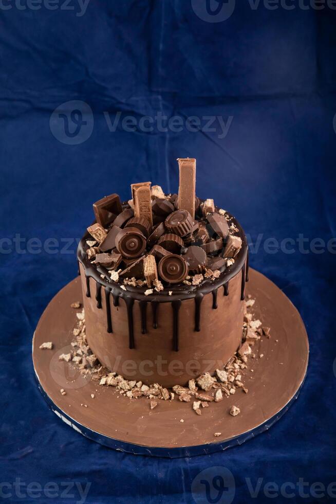 Chocolate Overloaded Cake with rose flowers, knife and fork served on board isolated on napkin side view of cafe baked food photo