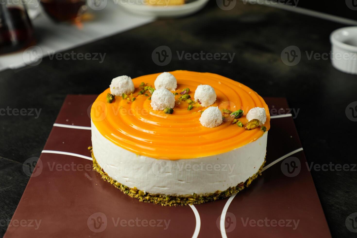 Mango Yogurt Cake topping with pistachio fork and flowers served in plate isolated on napkin side view cafe bake food photo
