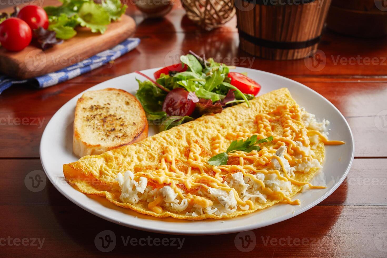 Triple Cheese omelette roll with salad served in a dish isolated on wooden background side view photo