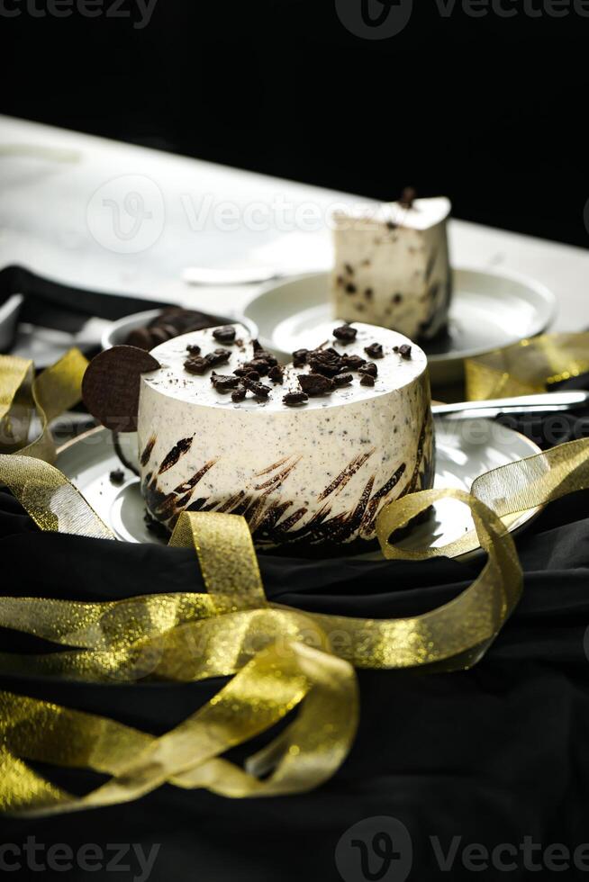 Oreo Cheesecake slice include chocolate, cream, sugar with fork and flowers served in plate isolated on napkin side view of cafe food photo