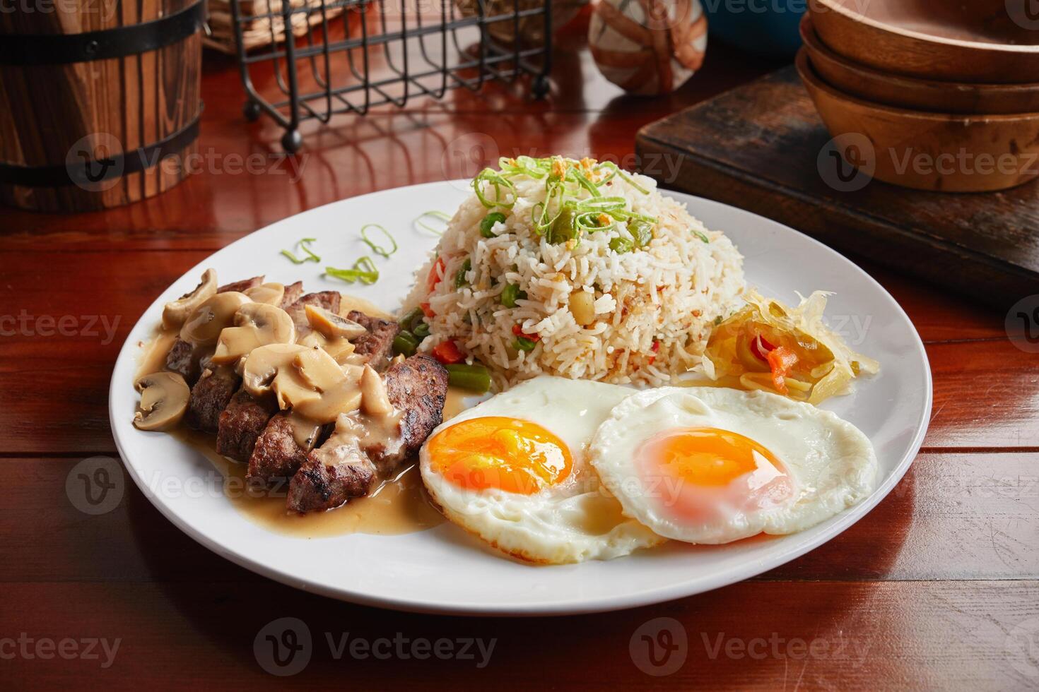 Brunch breakfast with beef, fried rice and eggs served in a dish isolated on wooden background side view photo