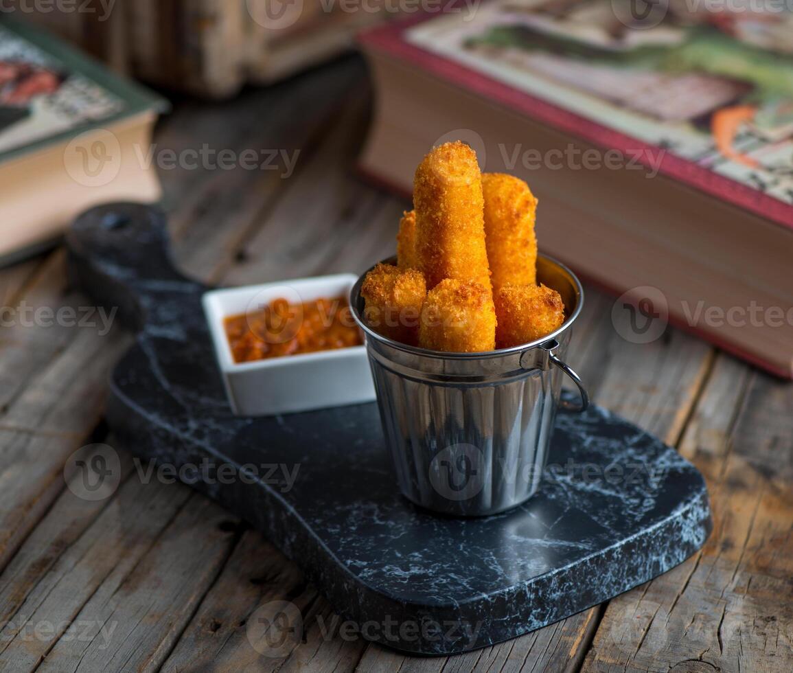 deep-fried cheese finger served in a dish isolated on wooden background side view of appetizer photo