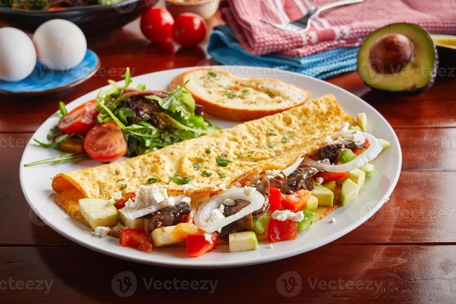 Zucchini omelette roll with salad served in a dish isolated on wooden background side view photo