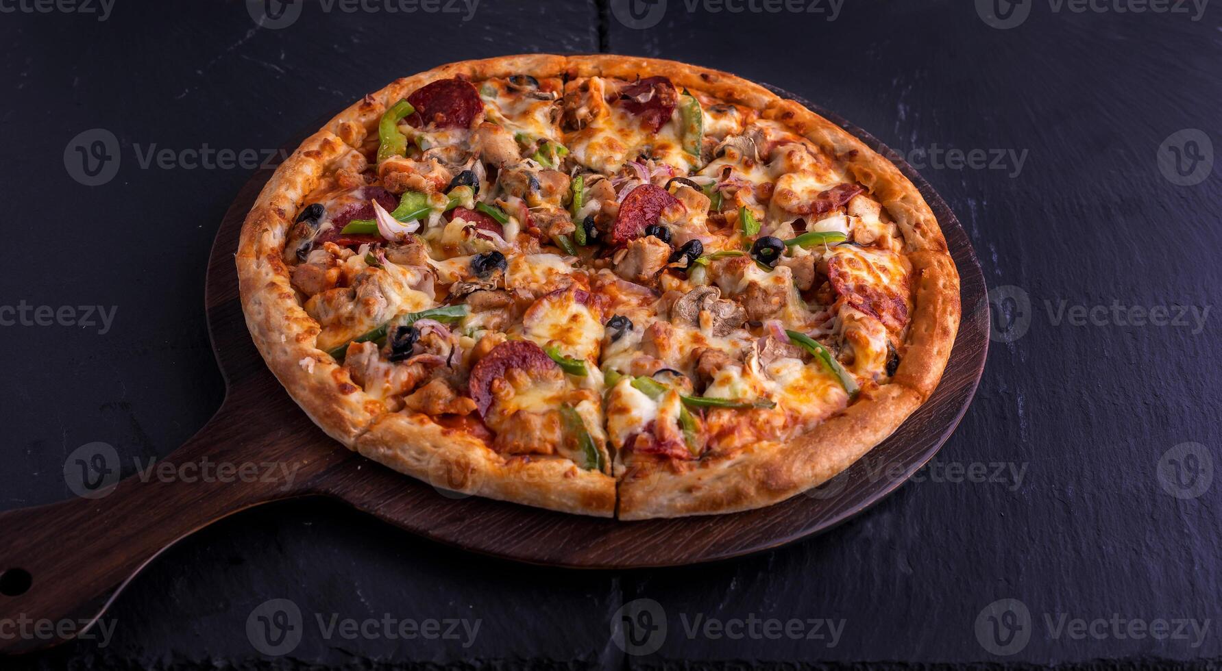 Chicken Supreme pizza isolated on cutting board top view on dark background italian fast food photo