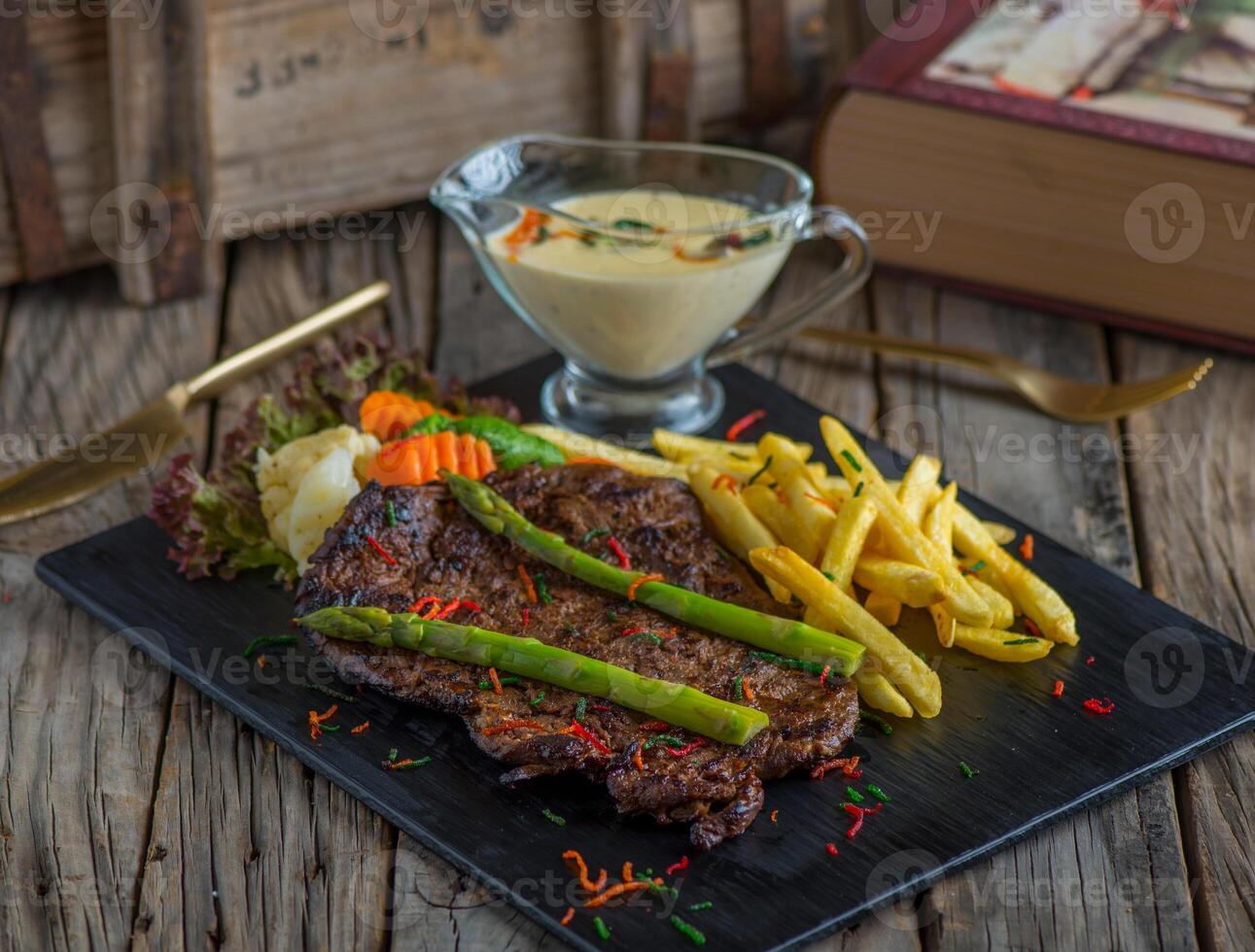 beef steak with fries isolated on cutting board on wooden background side view of steak photo
