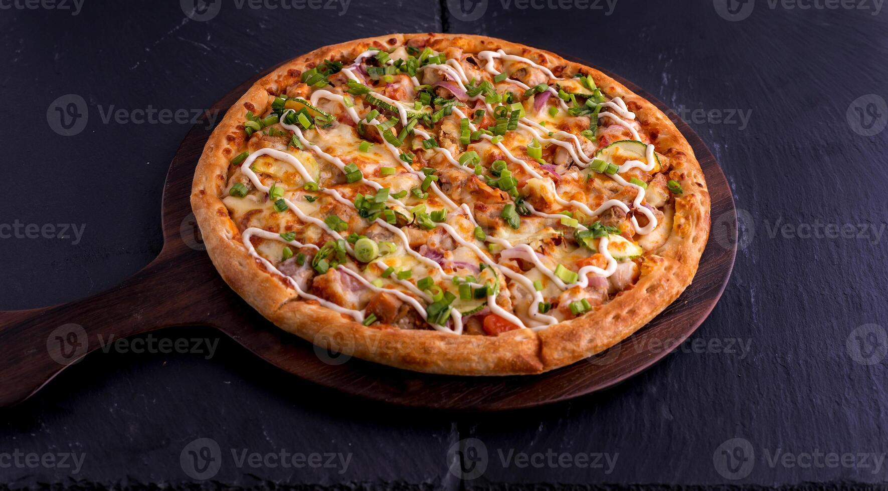Hot and Sour Chicken pizza isolated on cutting board top view on dark background italian fast food photo