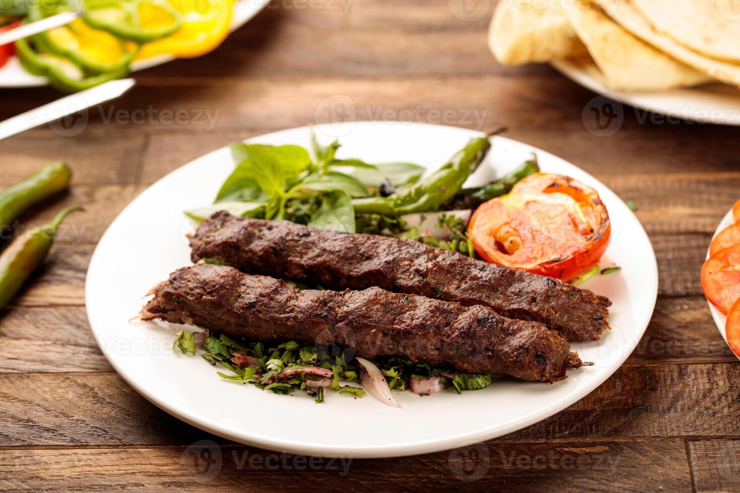 Beef Kebab with salad served in a dish isolated on wooden table background side view of fastfood photo