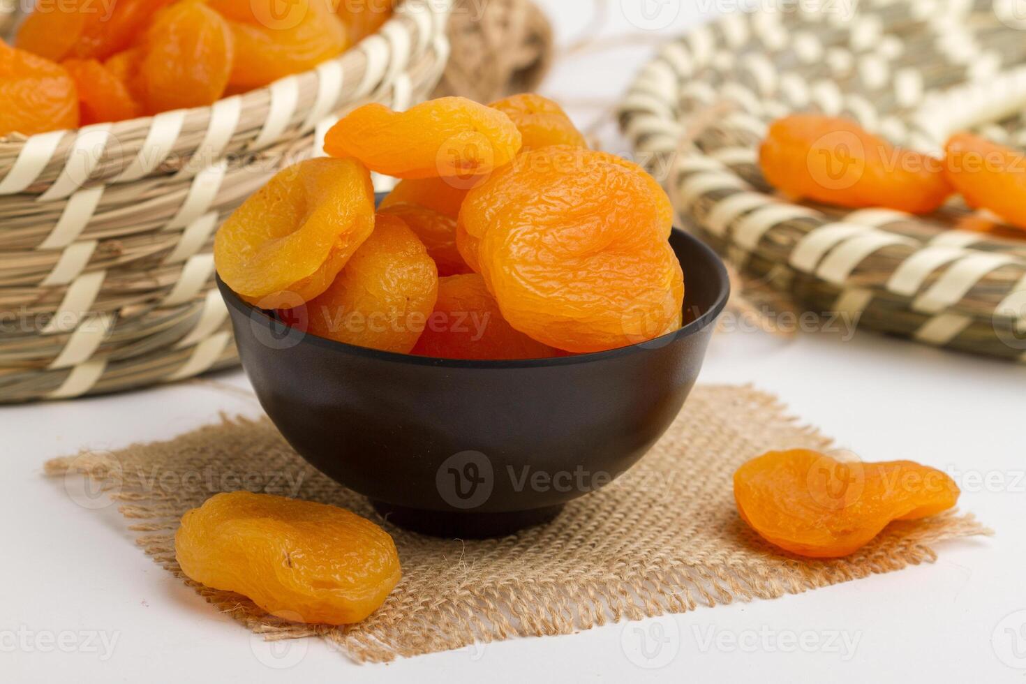 Apricot served in bowl isolated on napkin side view of dry fruits on grey background photo