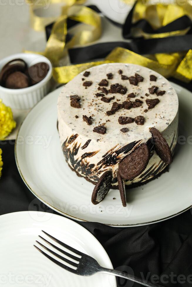 Oreo Cheesecake include chocolate, cream, sugar with fork and flowers served in plate isolated on napkin side view of cafe food photo