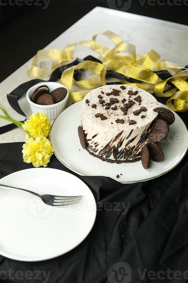Oreo Cheesecake include chocolate, cream, sugar with fork and flowers served in plate isolated on napkin side view of cafe food photo
