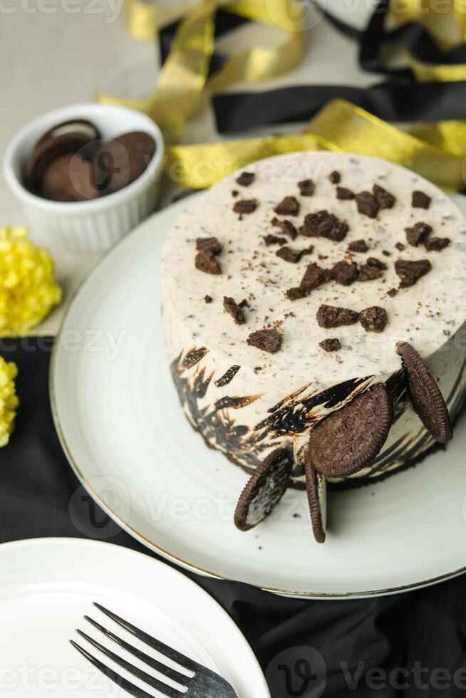 Oreo Cheesecake include chocolate, cream, sugar with fork and flowers served in plate isolated on napkin side view of cafe food photo