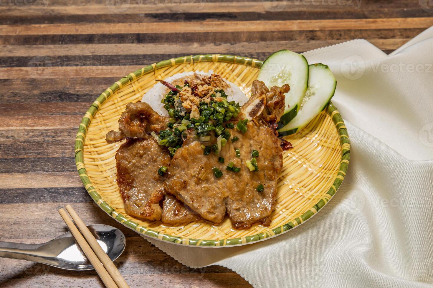 Pork chop curry with rice, cucumber and chopsticks served in dish isolated on wooden table top view of hong kong fast food photo
