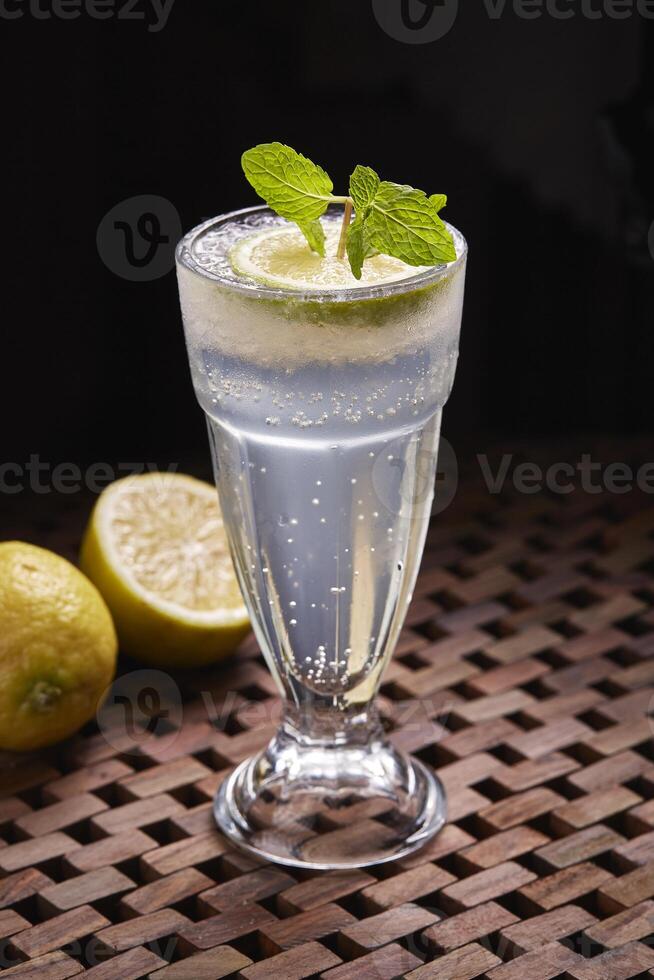 Sparkling Lemonade cocktail soda Drink with leon slice served in glass isolated on table side view of middle east food photo