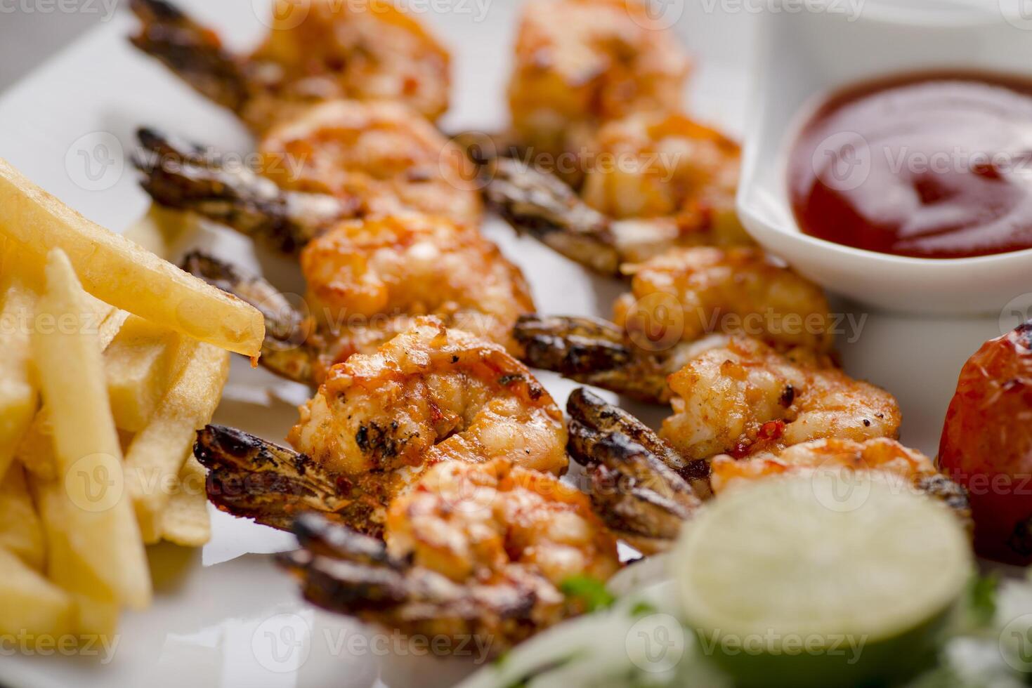 grilled shrimp with tomato sauce and lime served in dish isolated on grey background top view of arabic food photo