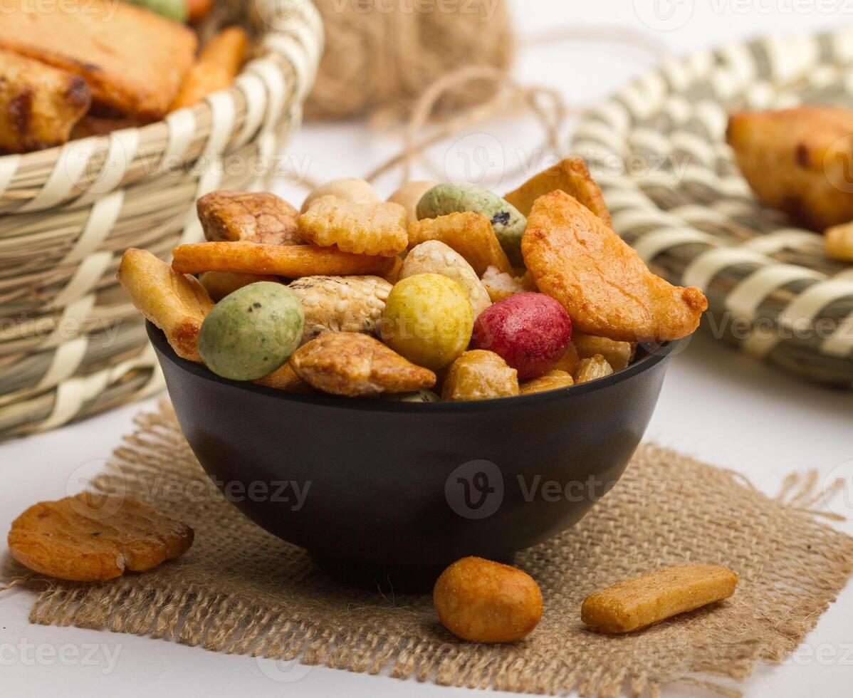 Japnese rice crackers served in a bowl isolated on napkin side view of nuts on grey background photo