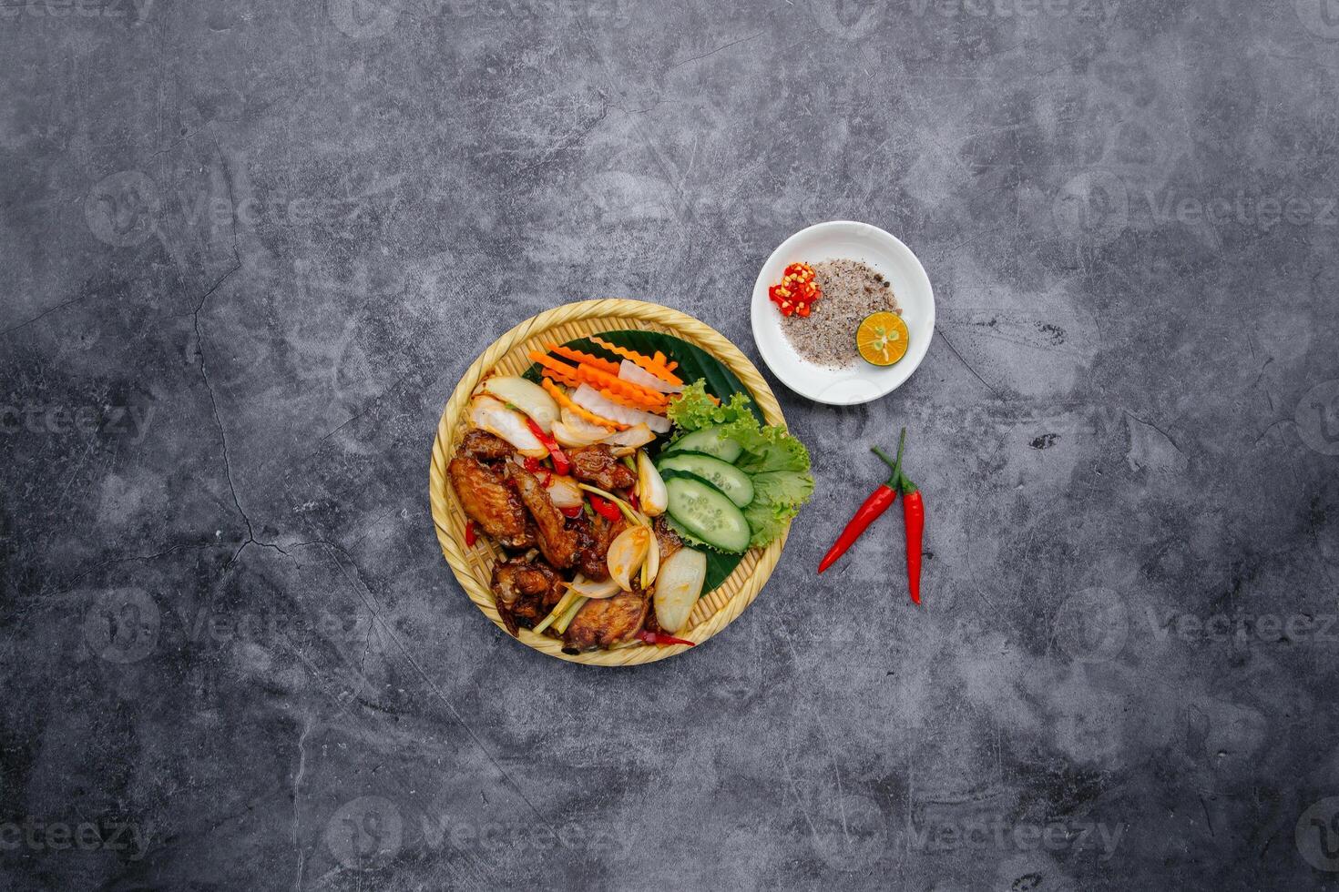 Deep Fried Chicken Wings With Fish Sauce and salad served in bowl isolated on dark grey background top view of japanese food photo