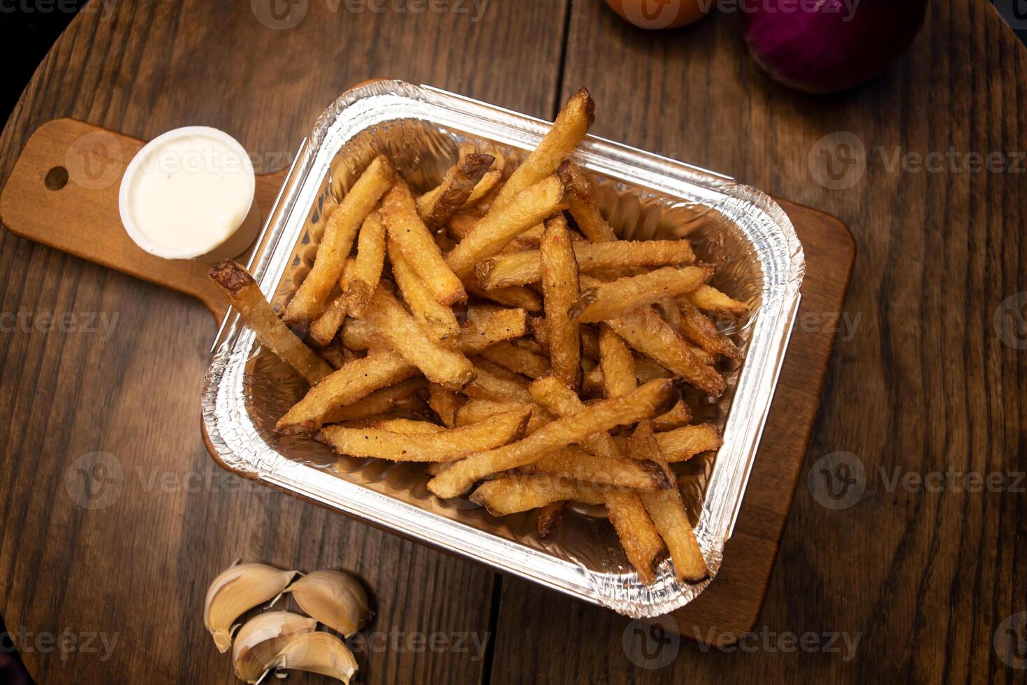 Regular French Fries with mayo dip served in dish isolated on wooden board top view of junk fastfood photo