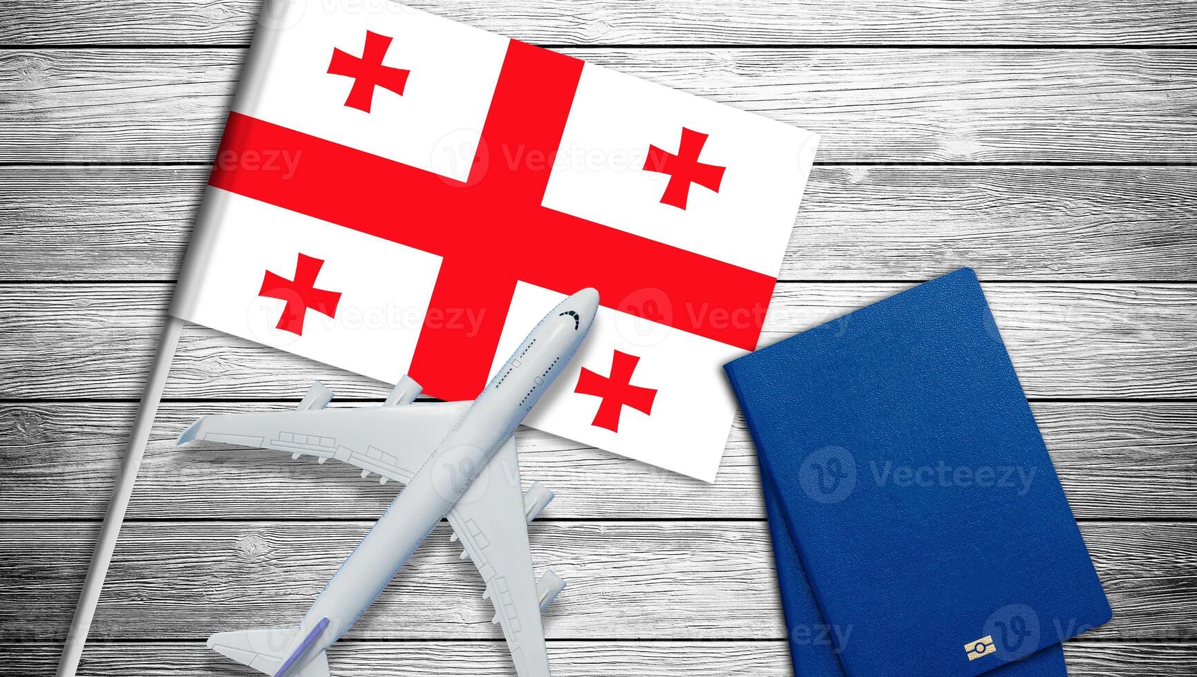 Flag of Georgia with passport and toy airplane. Flight travel concept photo