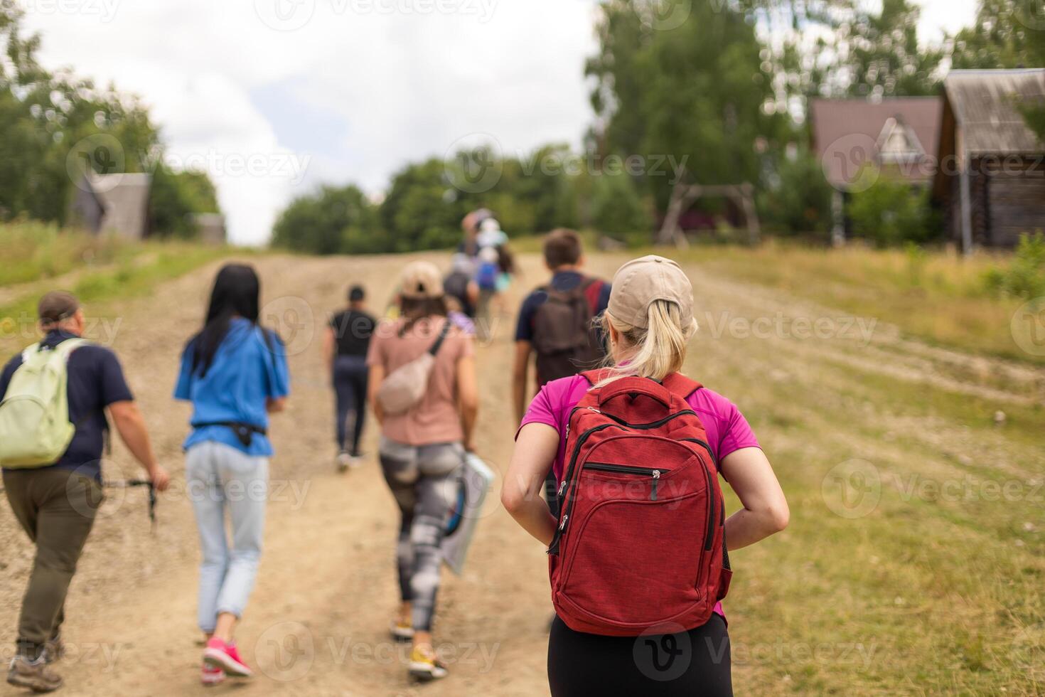 Group of friends trekking with backpacks walking in the forest. photo