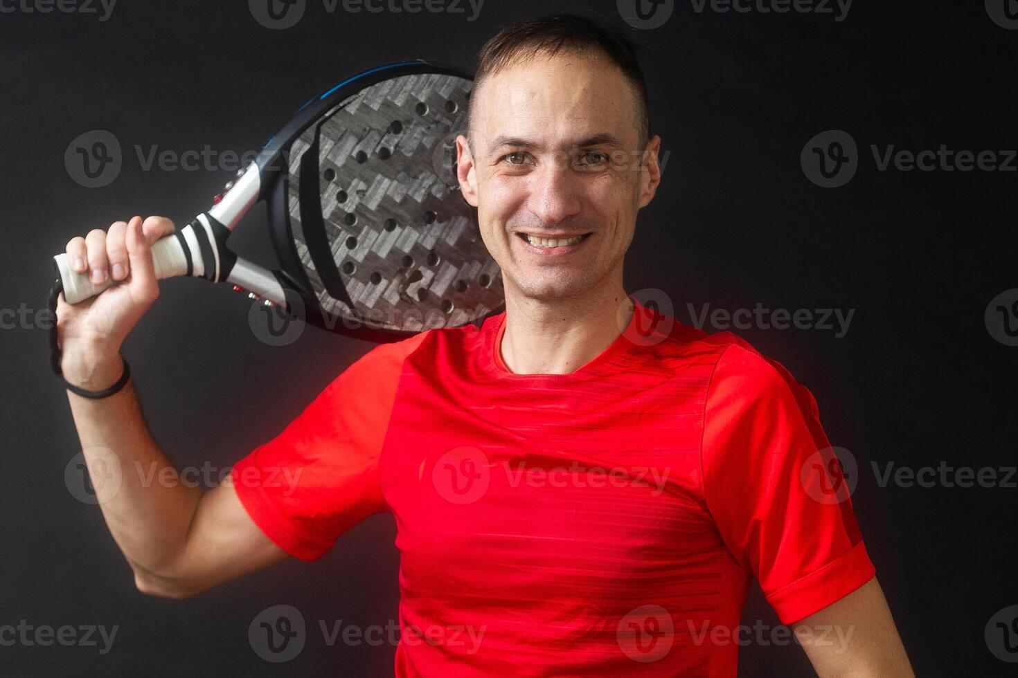 Smiling man with racket and paddle ball dressed in sport clothes isolated background. Front view. photo