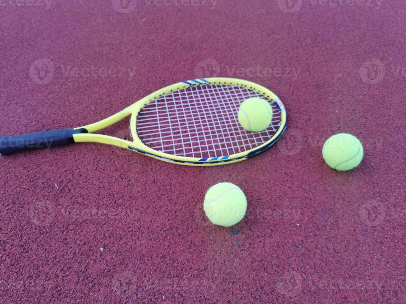 Tennis. Tennis ball and racket on a red background of tennis court with copy space. Sport and healthy lifestyle. The concept of outdoor game sports. photo