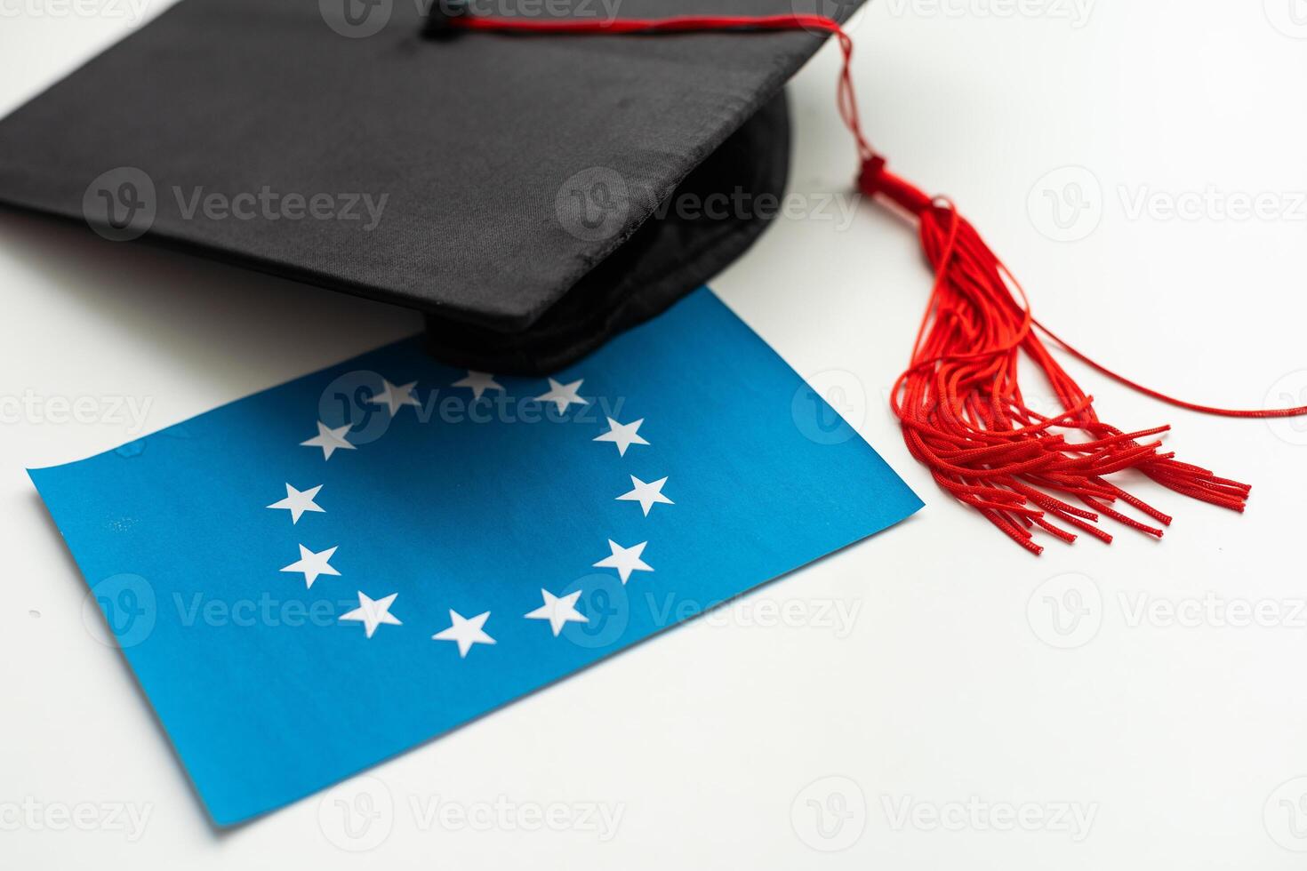 Graduation cap with red tassel isolated on white background photo