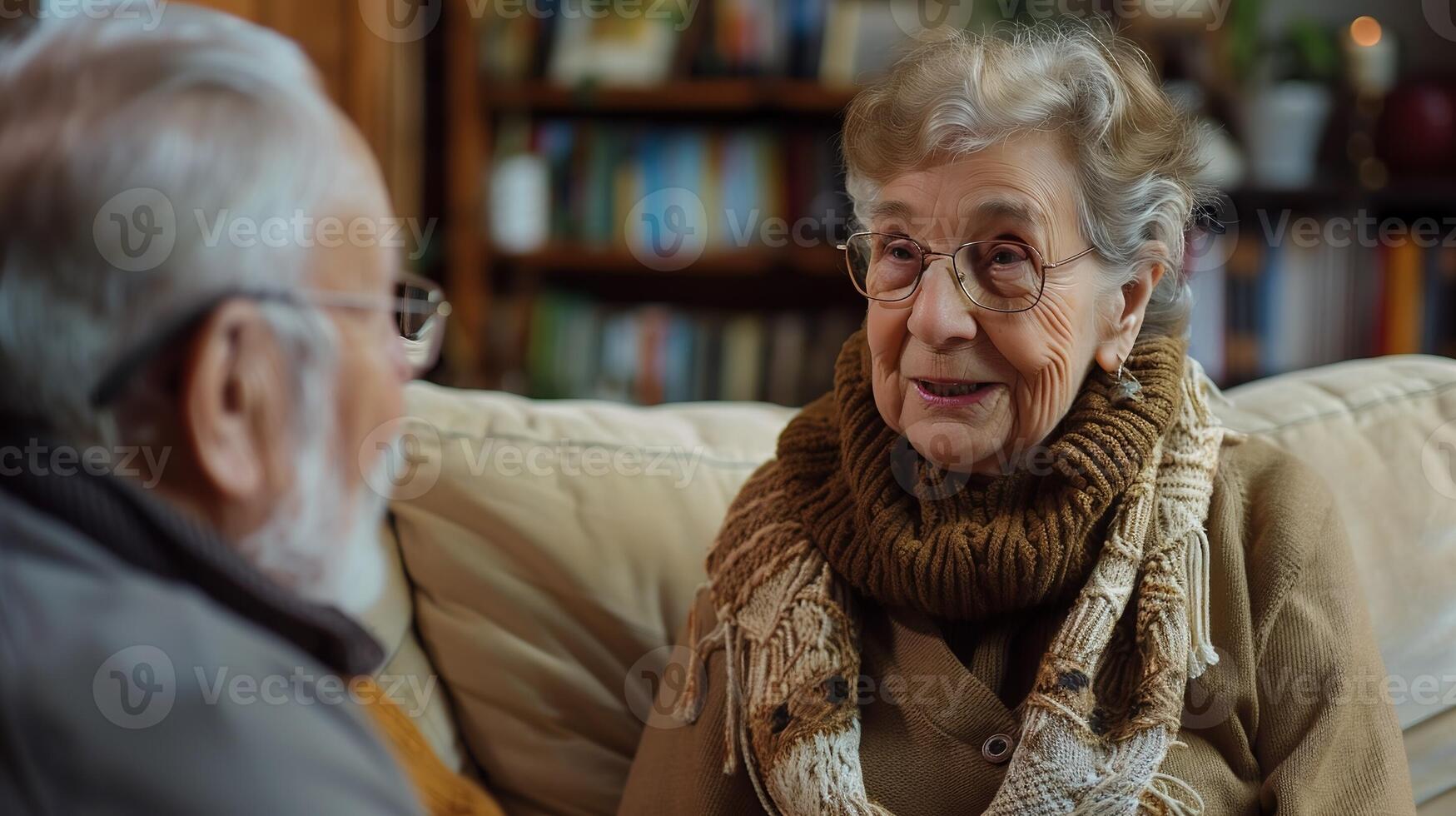 AI Generated Senior caucasian woman and man pensioner husband and wife sitting on the couch at home - Old age people married couple retirement and togetherness concept selective focus on female photo