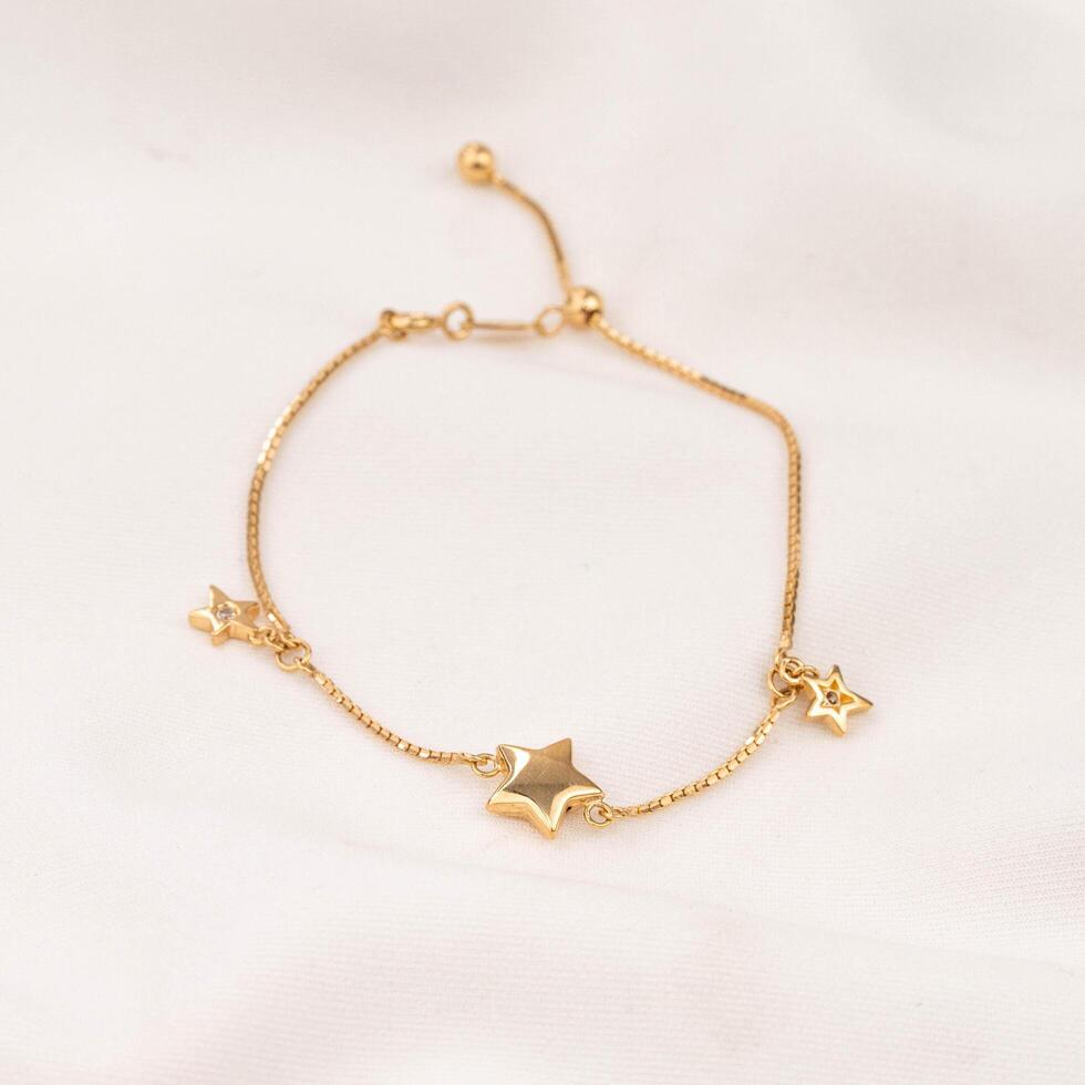 oro pulsera joyería con hermosa estrellas foto