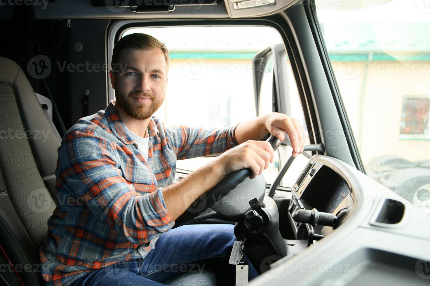 Side view of professional driver behind the wheel in truck's cabin. photo