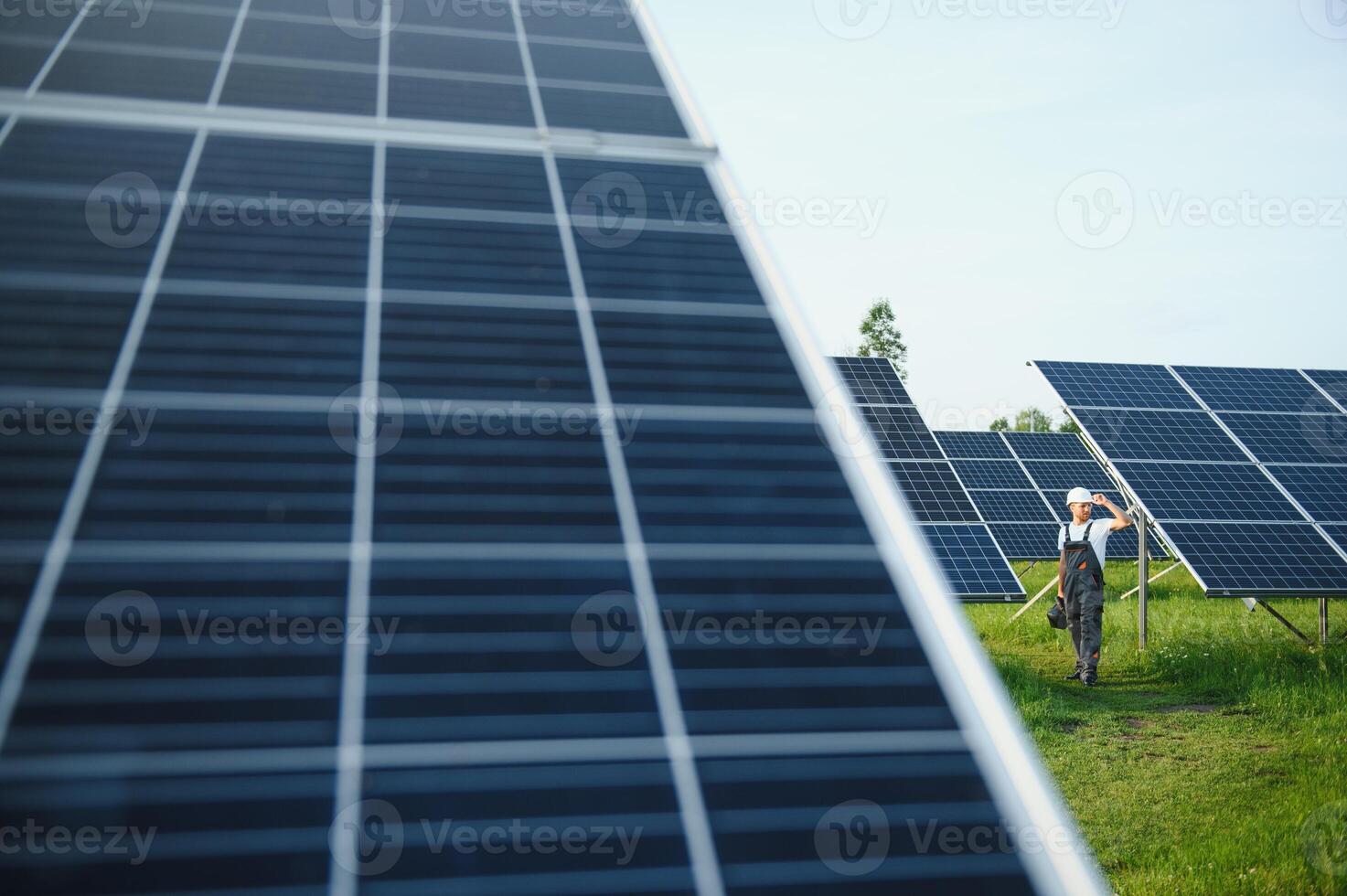 a worker walks through a solar panel farm photo