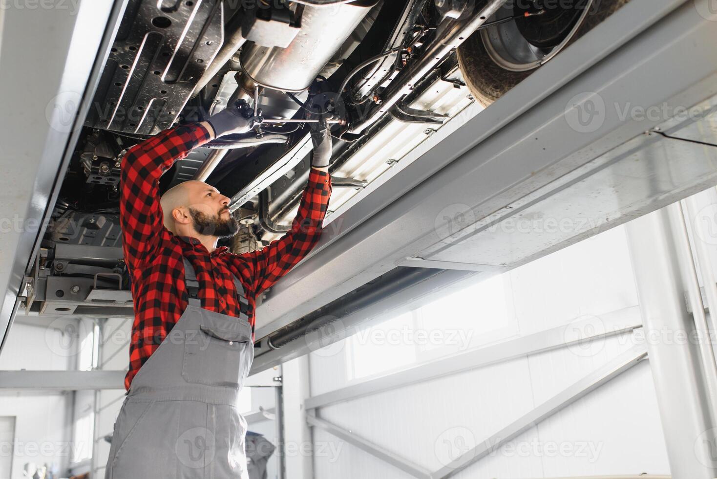 Auto mechanic working at auto repair shop photo
