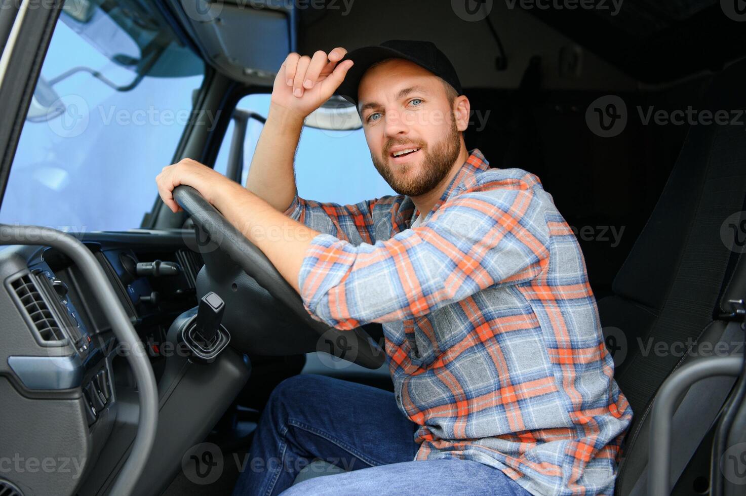 Side view of professional driver behind the wheel in truck's cabin. photo