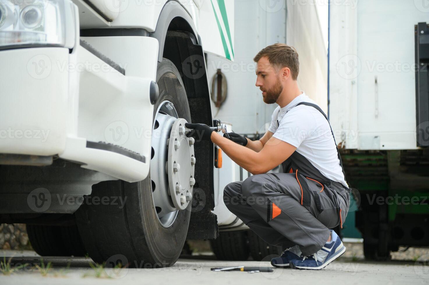 Caucasian Professional Truck Mechanic Rebuilding Heavy Duty Truck Diesel Engine. Automotive Industry Theme. photo