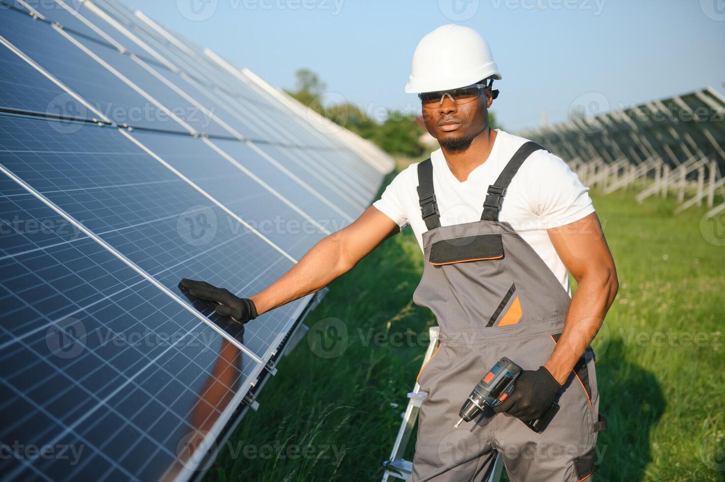 retrato de africano americano electricista ingeniero en la seguridad casco y uniforme instalando solar paneles foto