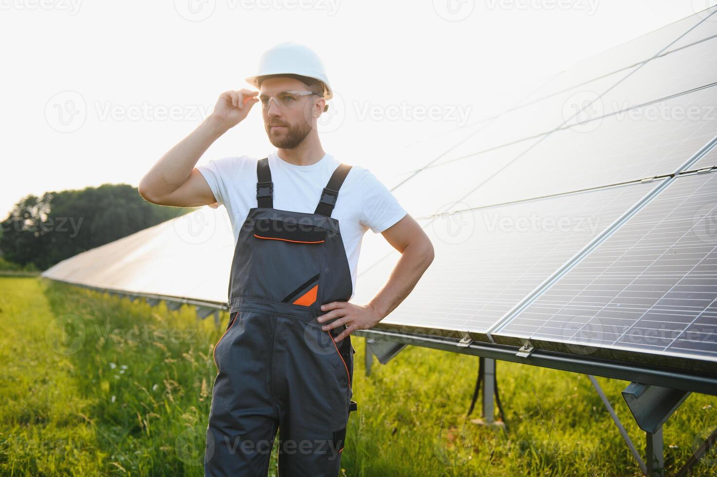 lado ver de masculino trabajador instalando solar módulos y apoyo estructuras de fotovoltaica solar formación. electricista vistiendo la seguridad casco mientras trabajando con solar panel. concepto de Dom energía foto